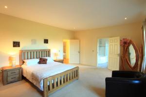 a bedroom with a large bed and a mirror at Bun Cill Athat in Kenmare