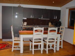 eine Küche mit einem Tisch und Stühlen sowie einem Kühlschrank in der Unterkunft Haus Weichart in Sulzburg