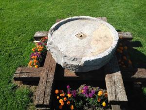 Lezamakoetxe في Sopuerta: مقعد حجري عليه زهور على العشب