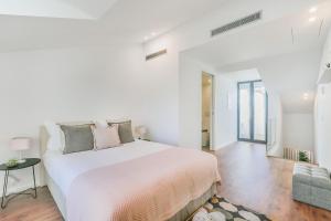 - une chambre blanche avec un grand lit et un canapé dans l'établissement Porto City Elegant Retreat, à Porto