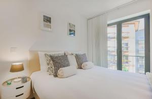 een witte slaapkamer met een groot bed en een raam bij Porto City Elegant Retreat in Porto