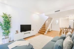 ein Wohnzimmer mit einem blauen Sofa und einem TV in der Unterkunft Porto City Elegant Retreat in Porto