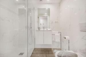 a white bathroom with a shower and a sink at Porto City Elegant Retreat in Porto