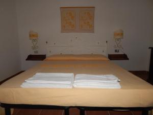 a bedroom with a bed with two white towels on it at Residence Spiaggia Bianca in Golfo Aranci