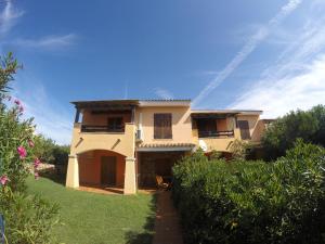 a large house with a pathway in front of it at Residence Spiaggia Bianca in Golfo Aranci