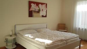 - une chambre dotée d'un lit blanc avec une photo sur le mur dans l'établissement Ferienwohnung Bea in Rheine, à Rheine