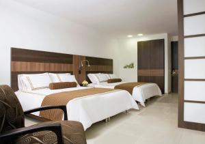 Una cama o camas en una habitación de San Simon Hotel Pereira