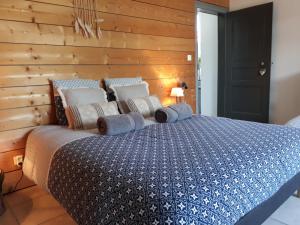 1 dormitorio con 1 cama con pared de madera en Gite Aux Lauriers, en Lacroix-sur-Meuse
