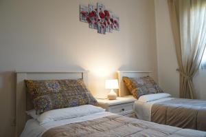 ein Schlafzimmer mit 2 Betten und einem Tisch mit einer Lampe in der Unterkunft La Bouganville di Sante e Rosa in Manoppello