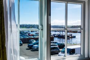 a window view of a marina with cars parked at The Corner House in Whitby +3 photos