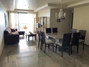 a dining room and living room with a table and chairs at Amplo apartamento em Guarapari com vistas pro mar in Guarapari