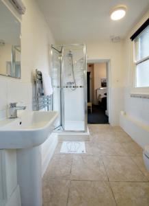 a white bathroom with a sink and a shower at Galtres Lodge Hotel & Forest Restaurant in York