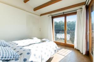 sypialnia z łóżkiem i dużym oknem w obiekcie Masia el Prat w mieście El Pont de Vilomara