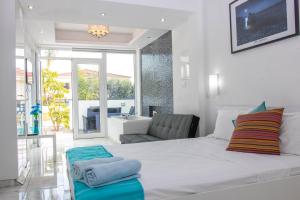 a bedroom with a large white bed and a living room at Nissi49 Apartments in Ayia Napa