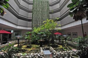 arium de un edificio con un jardín con árboles en TH Hotel Kelana Jaya, en Petaling Jaya