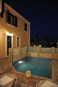 a swimming pool in front of a house at night at Crete Residence Villas in Panormos Rethymno