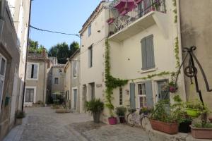 an alley in an old town with potted plants at La maison du Plo in Fabrezan