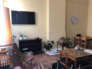 uma sala de estar com uma televisão e uma mesa e cadeiras em Boomerang Antwerp em Antuérpia