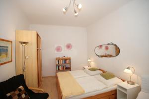 um quarto com uma cama, uma cadeira e um espelho em Freundliches Apartment mit Innenhof-Garten em Viena