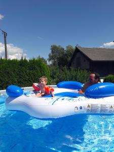 a man and a young boy riding on an inflatable at Fewo's Sieberer in Kirchbach