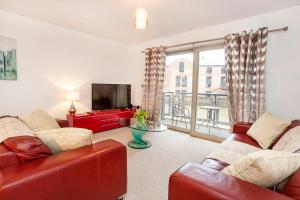 a living room with two red couches and a television at 16 John Walker House in York