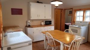 cocina con armarios blancos y mesa de madera en Riverside Resort en Richmond