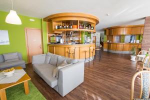 a living room with a couch and a bar at Hotel & Residence Montana in Fai della Paganella
