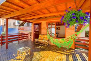 a porch with a hammock on a house at Pousada Cantinho Colibri in Monte Verde