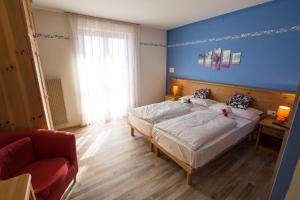 een slaapkamer met 2 bedden en een blauwe muur bij Hotel Montana in Fai della Paganella