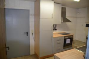 cocina con armarios blancos y puerta abierta en Ferienwohnung Auf dem Quellberg, en Dulmen