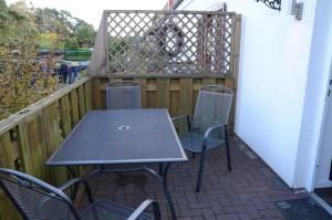 une table et des chaises sur une terrasse avec une clôture dans l'établissement FH Hannahliese_WEND, à Karlshagen