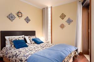 una camera da letto con un letto grande con cuscini blu di BARRAMARES 1 a Furadouro Altre 26 foto
