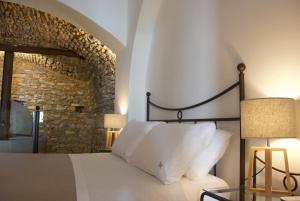 Santo Mercurio Country House في بيسكيوتا: غرفة نوم بسرير وجدار حجري
