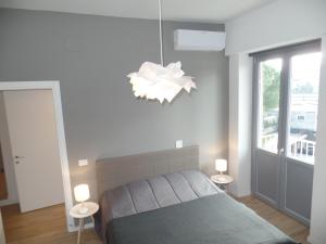 a bedroom with a bed and a chandelier at Residenza Vittorio Emanuele in Gorizia