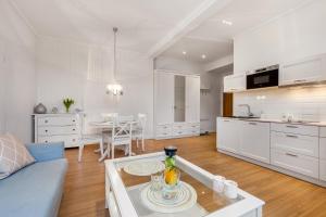 eine Küche und ein Wohnzimmer mit einem Sofa und einem Tisch in der Unterkunft Apartamenty Black&White - Apartament Royal - free parking in Sopot