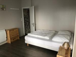 um pequeno quarto com uma cama e uma cómoda em Les Roches Yportaises em Yport