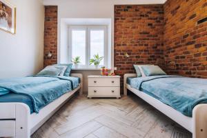 2 Betten in einem Zimmer mit Ziegelwand in der Unterkunft BRAND NEW ! Lovely Apartment in the fabulous location OLD TOWN JEWISH TOWN WAWEL CASTLE in Krakau