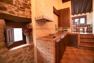 a kitchen with a counter and a stone wall at Abuela Pastora in El Torno