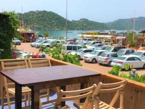 a balcony with a table and chairs and a parking lot at Gonul Pansiyon in Kaleucagız