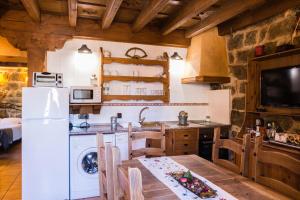 a kitchen with a white refrigerator and a table at El Mirador del Alberche in Navaluenga