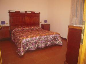 スルツァーノにあるUlivetoのベッドルーム1室(花柄のベッドカバー付)