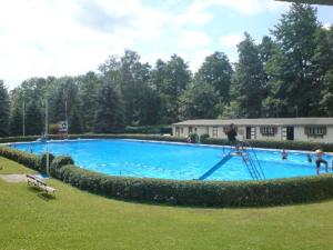 una persona en una escalera en una gran piscina en Ferienapartment ''Zum Stollenkönig'', en Neustadt