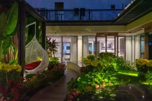 arium of a building with a hammock in a garden at KP Hotel in Can Tho