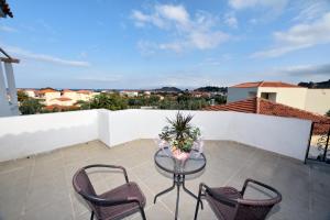 a patio with a glass table and two chairs at chalkiotis hotel in Anaxos