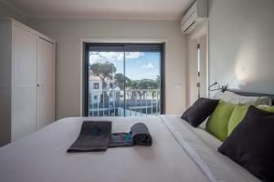 a white bed with a pair of glasses on it at BeGuest Sun & Pool House in Parede