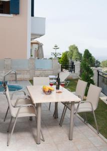 a table and chairs with a bowl of fruit on a patio at Crete Residence Villas in Panormos Rethymno