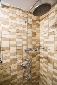 La salle de bains est pourvue d'une douche avec un pommeau de douche. dans l'établissement ALKAMENOUS APARTMENT PETROS vipgreece., à Athènes