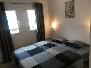 2 Betten in einem Schlafzimmer mit 2 Fenstern in der Unterkunft Luxury Apartment in Corralejo + 22 Fotos