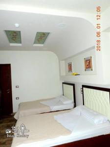 2 nebeneinander sitzende Betten in einem Schlafzimmer in der Unterkunft St. Marie House in Asyut