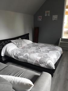 a bedroom with a large bed and a couch at la ville à la campagne in Lisieux